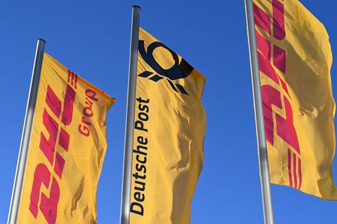 Eine Deutsche-Post-Fahne an der Konzernzentrale, umrahmt von DHL-Fahnen. Foto: Wolf von Dewitz/dpa