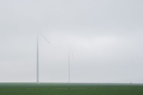 Windräder verblassen bei Regen in tief hängenden Nebelschwaden in der Region Hannover. Foto: Julian Stratenschulte/dpa