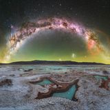 Tief in die argentinische Puna drang der Fotograf Daniel Viñé Garcia vor. Die Hochwüste liegt mehr als 3.500 Meter über dem Meeresspiegel. Dort, weit entfernt von jeglicher Lichtverschmutzung, inmitten der minimalistischen Landschaft einer Salzebene, offenbarte sich ihm ein Himmelsbogen, auf dem links das Zentrum unserer Galaxie sieht und rechts den rötlichen Gum-Nebel.