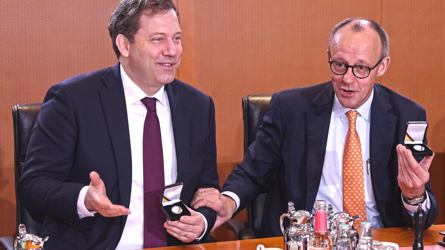 Lars Klingbeil und Friedrich Merz sitzen am Kabinettstisch und lachen