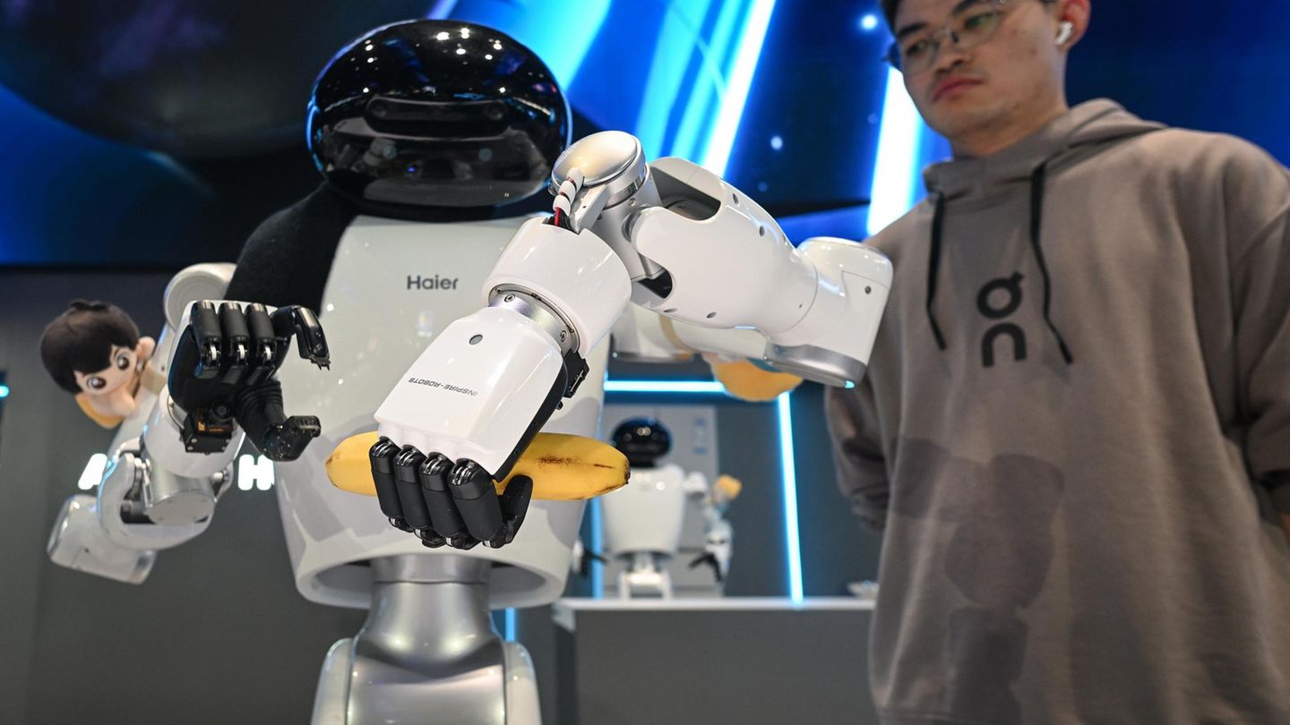 Mann neben Roboter mit zwei Händen
