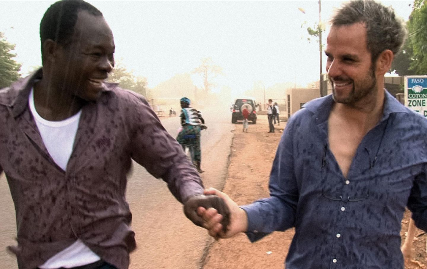 Francis Kéré und Christoph Schlingensief Hand in Hand auf der Straße