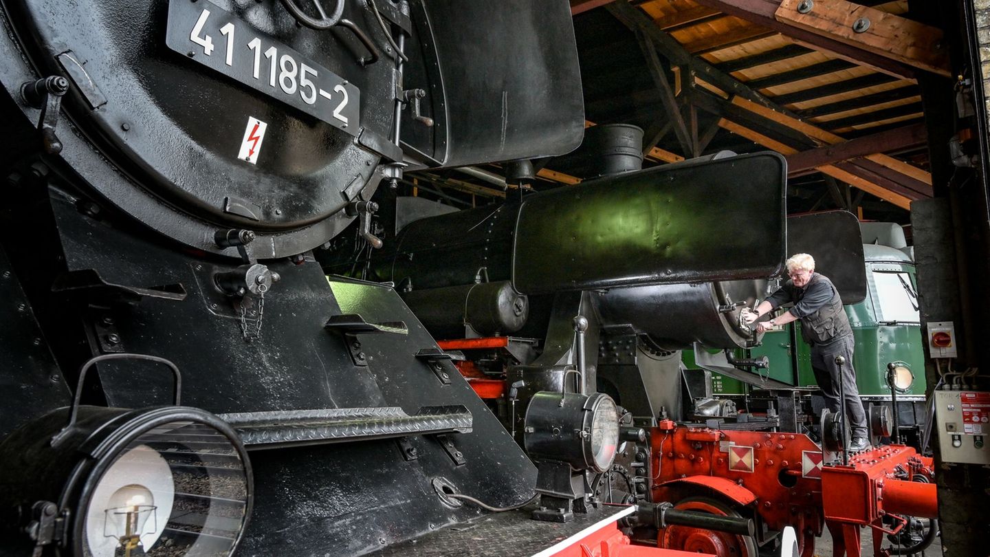 DB Museum Halle: Jörgen Seyffarth putzt eine Dampflok der Baureihe 52. Foto: Heiko Rebsch/dpa
