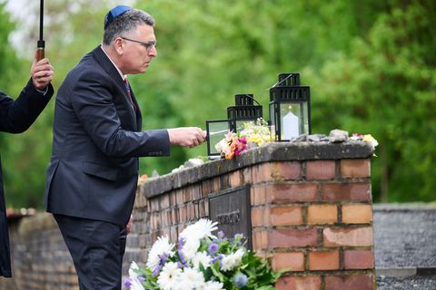 Israels Außenminister Gideon Saar zündet bei seinem Besuch am Mahnmal "Gleis 17" eine Kerze an. Foto: Annette Riedl/dpa