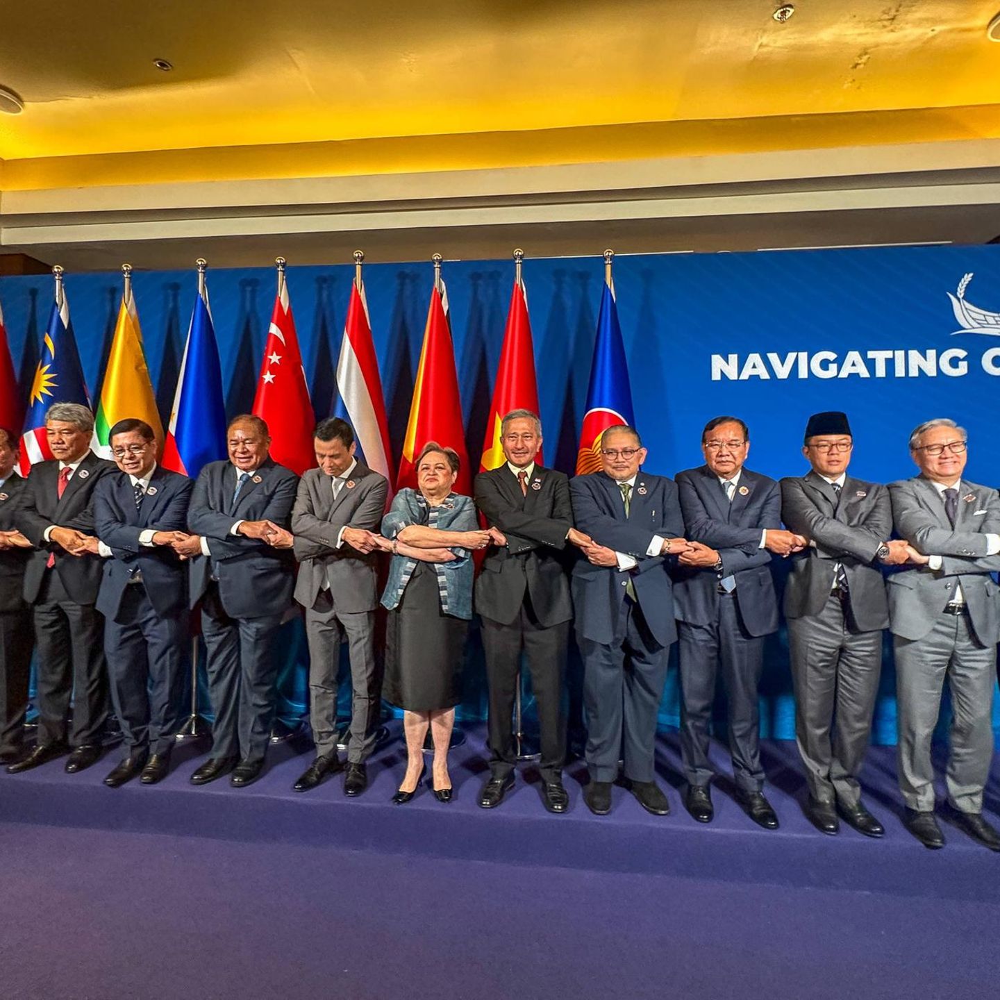 Cebu, Philippinen. Einheit symbolisieren, lautet die Devise: Die philippinische Außenministerin Theresa Lazaro (M.) und ihre männlichen Kollegen verschiedener Staaten halten sich während eines Gruppenfotos beim ASEAN-Außenministertreffen auf der Mactan Expo an den Händen – komplizierter, als es sein müsste.