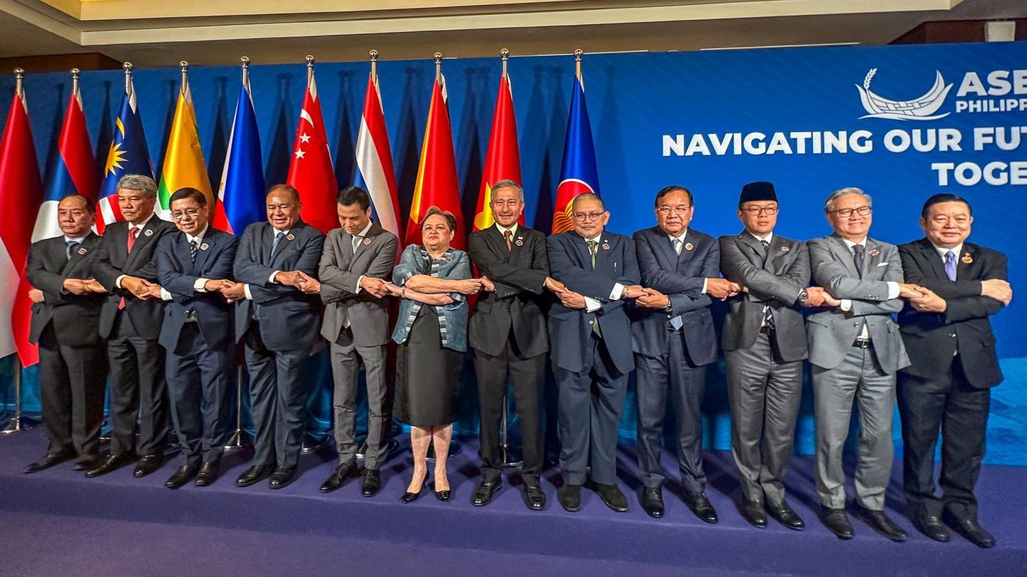 Cebu, Philippinen. Einheit symbolisieren, lautet die Devise: Die philippinische Außenministerin Theresa Lazaro (M.) und ihre männlichen Kollegen verschiedener Staaten halten sich während eines Gruppenfotos beim ASEAN-Außenministertreffen auf der Mactan Expo an den Händen – komplizierter, als es sein müsste.