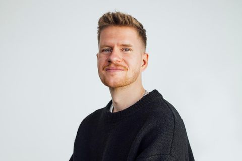 Podcaster Jonathan Rink blickt in die Kamera. Er trägt einen dunklen Pullover.