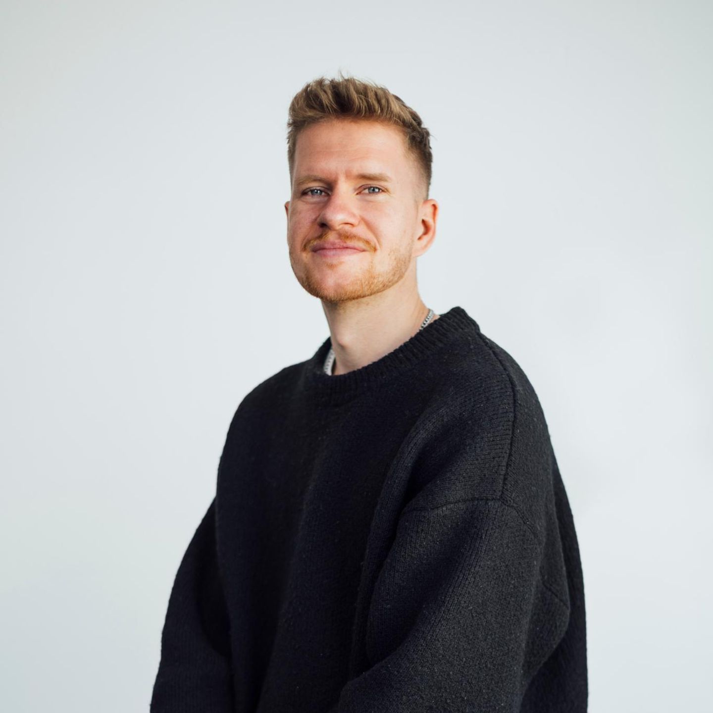 Podcaster Jonathan Rink blickt in die Kamera. Er trägt einen dunklen Pullover.