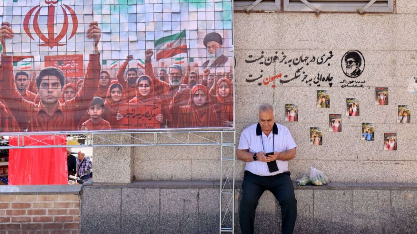 Mann schaut im Süden des Iran auf sein Handy