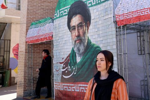 Frau vor Bild von Modschtaba Chamenei in Teheran
