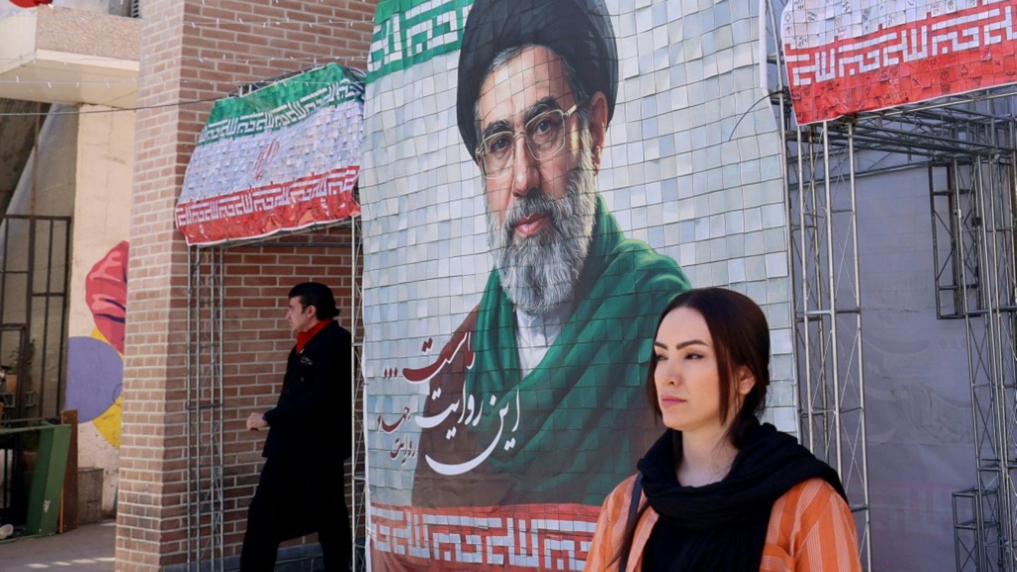 Frau vor Bild von Modschtaba Chamenei in Teheran