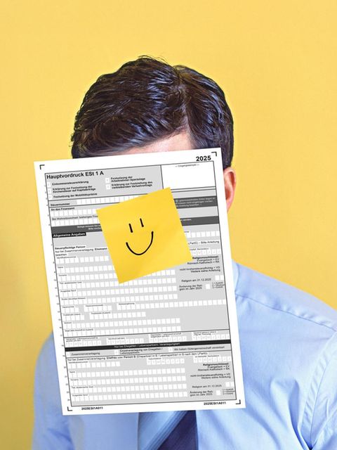 Ein Mann mit einer Steuererklärung vor dem Gesicht