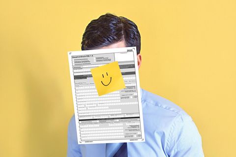 Ein Mann mit einer Steuererklärung vor dem Gesicht