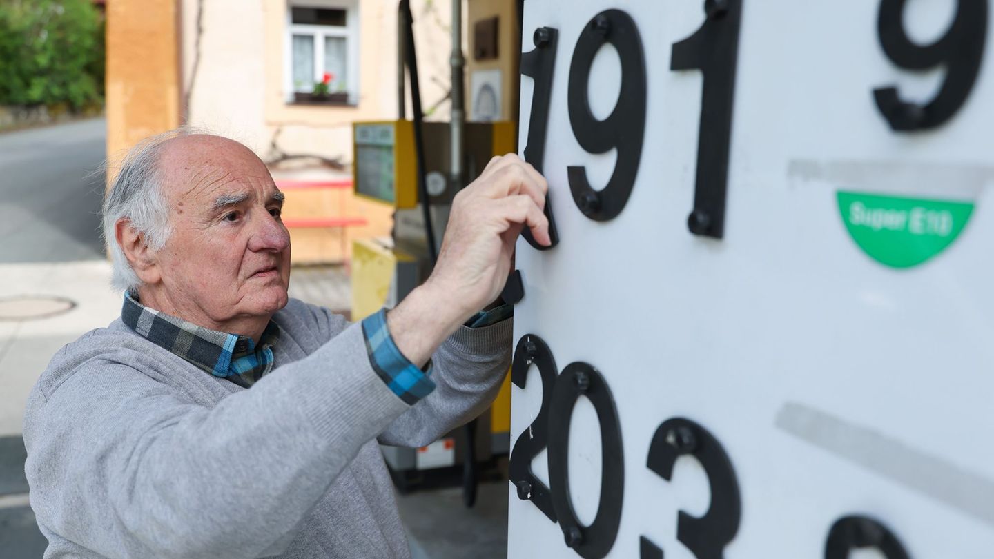 Herbert Brendel passt die Preisanzeige noch händisch an. Foto: Daniel Löb/dpa
