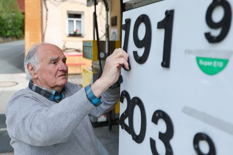 Herbert Brendel passt die Preisanzeige noch händisch an. Foto: Daniel Löb/dpa