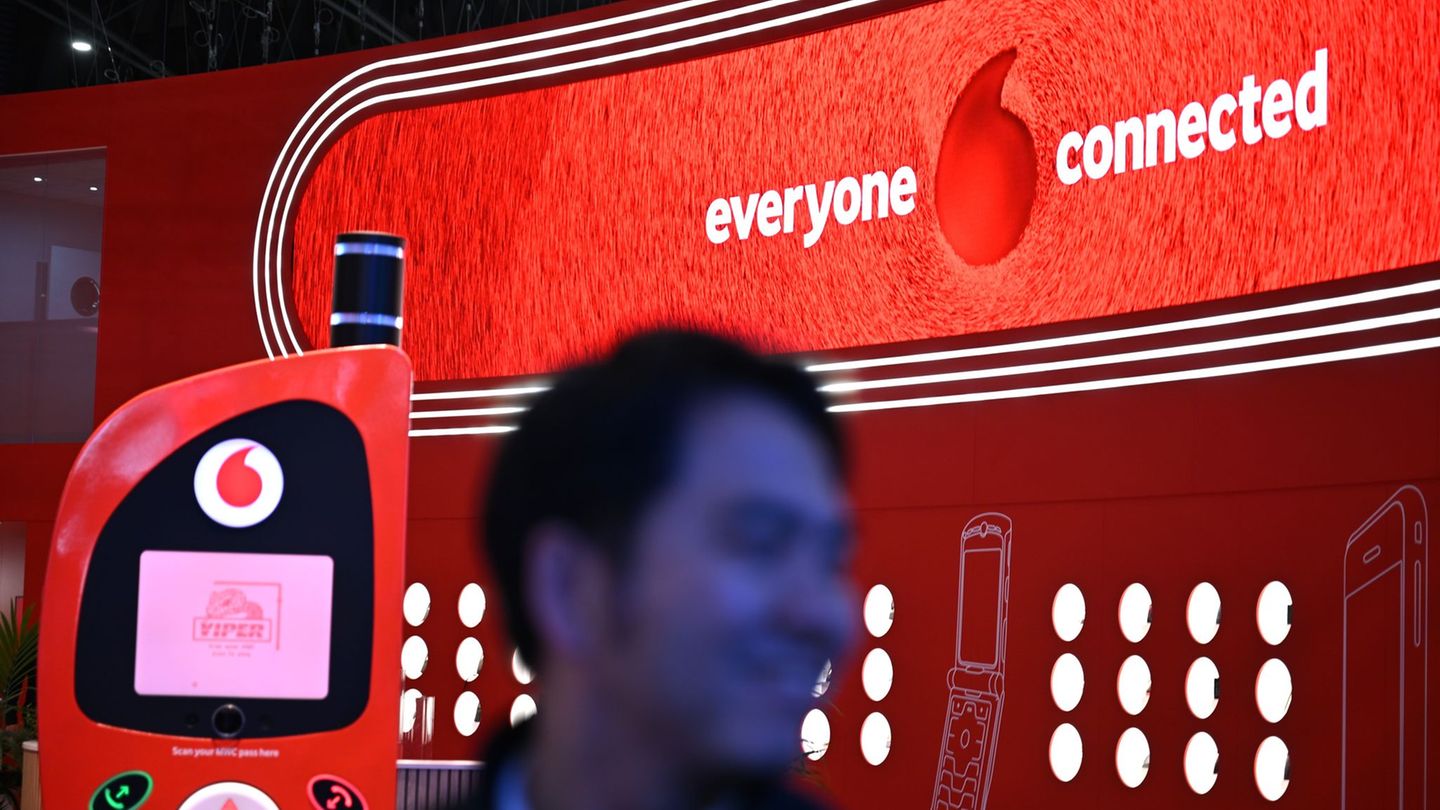 Der hat gut lachen: Ein Besucher der Mobilfunk-Messe MWC in Barcelona geht im März am Vodafone-Messestand vorbei, an dem ein übe
