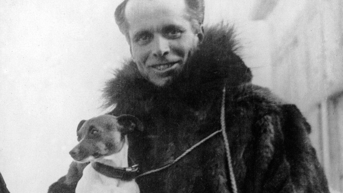 In warmer Kleidung sieht Umberto Nobile mit seinem Hund auf dem Arm in die Kamera.