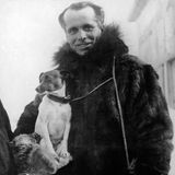 In warmer Kleidung sieht Umberto Nobile mit seinem Hund auf dem Arm in die Kamera.