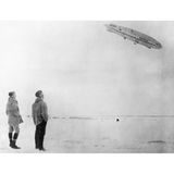 Amundsen und Ellsworth betrachten vom Boden aus die „Norge“ am Himmel.