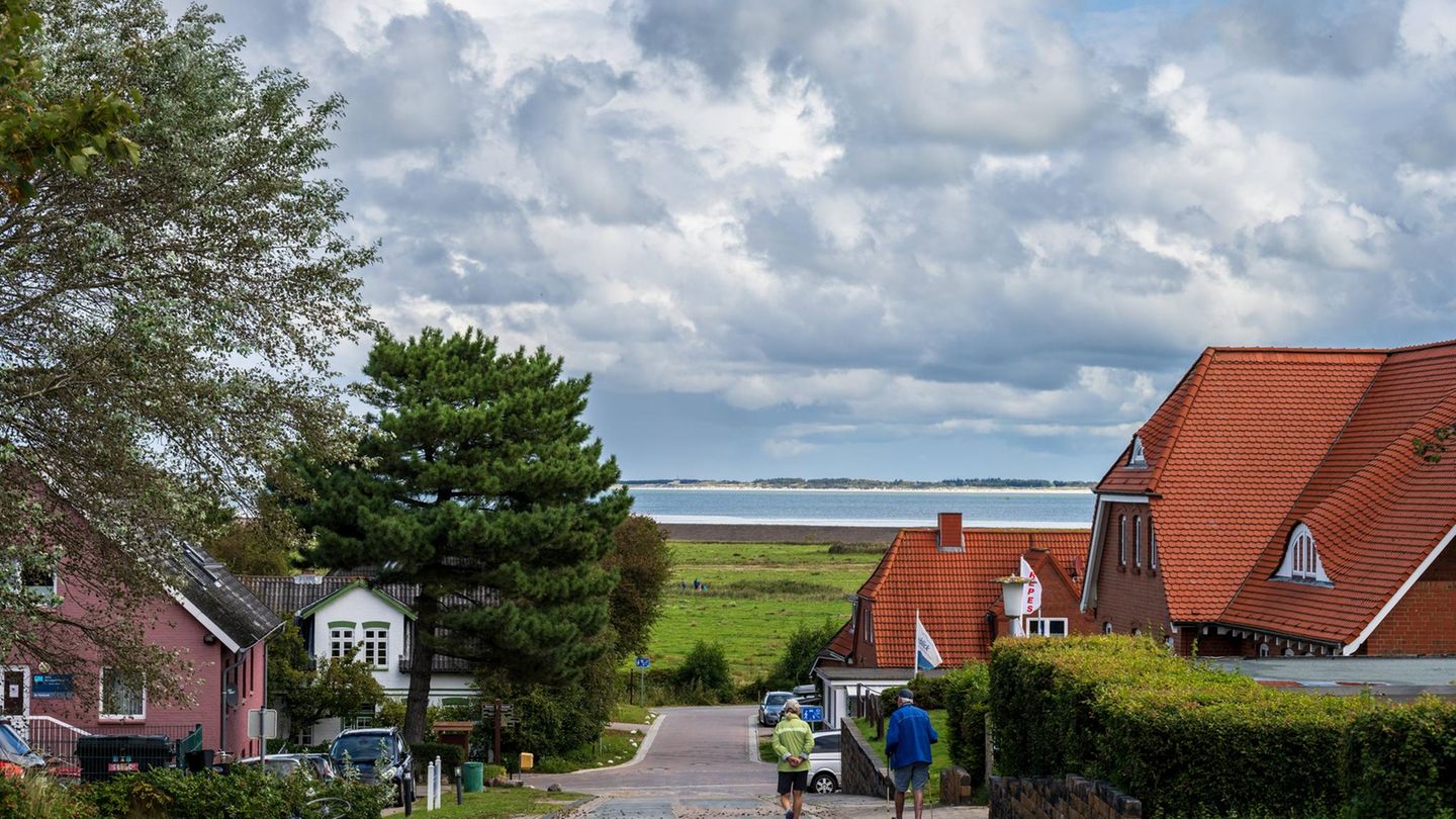 Straße in Norddorf auf Amrum mit Blick über die Salzwiesen, das Wattenmeer und die Indel Föhr am Horizont