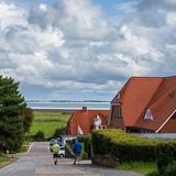 Straße in Norddorf auf Amrum mit Blick über die Salzwiesen, das Wattenmeer und die Indel Föhr am Horizont