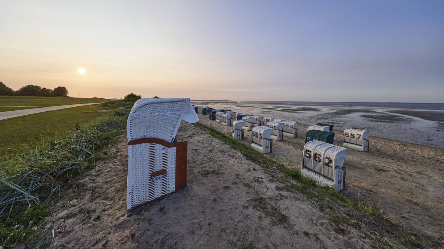Strand mit Strandkörben im Gegenlicht der untergehenden Sonne im Ortsteil Hooksiel