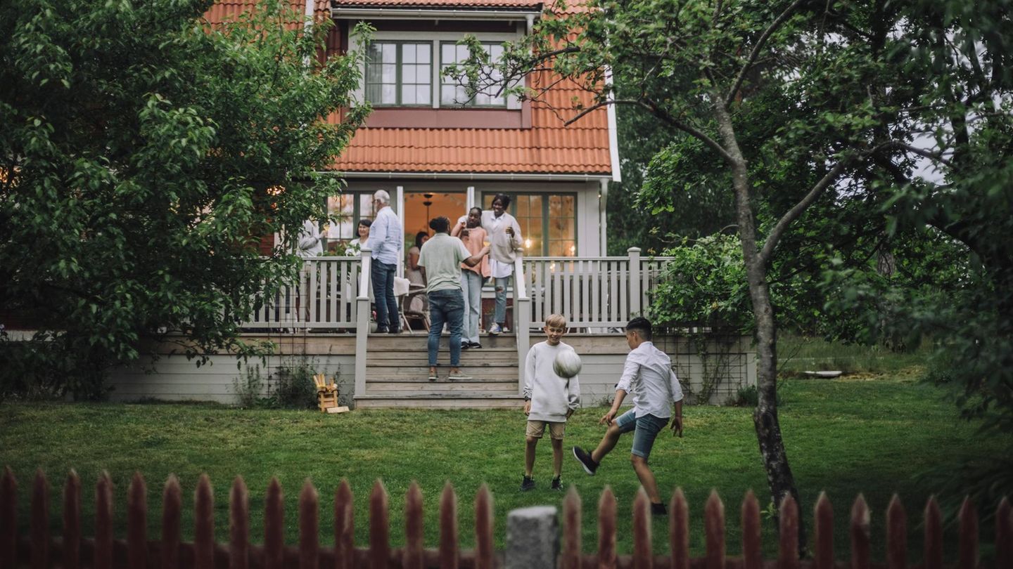 Eine Familie versammelt sich auf der Terasse vor einem Haus (Symbolbild Erbe)