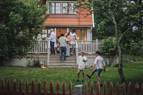Eine Familie versammelt sich auf der Terasse vor einem Haus (Symbolbild Erbe)
