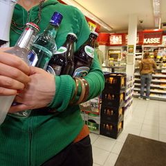 Eine Tankstellenbesucherin kauft Alkohol in einer Tankstelle