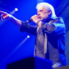 Peter Volkmann steht auf der Bühne und singt in ein Mikro