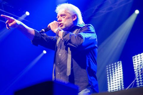 Peter Volkmann steht auf der Bühne und singt in ein Mikro
