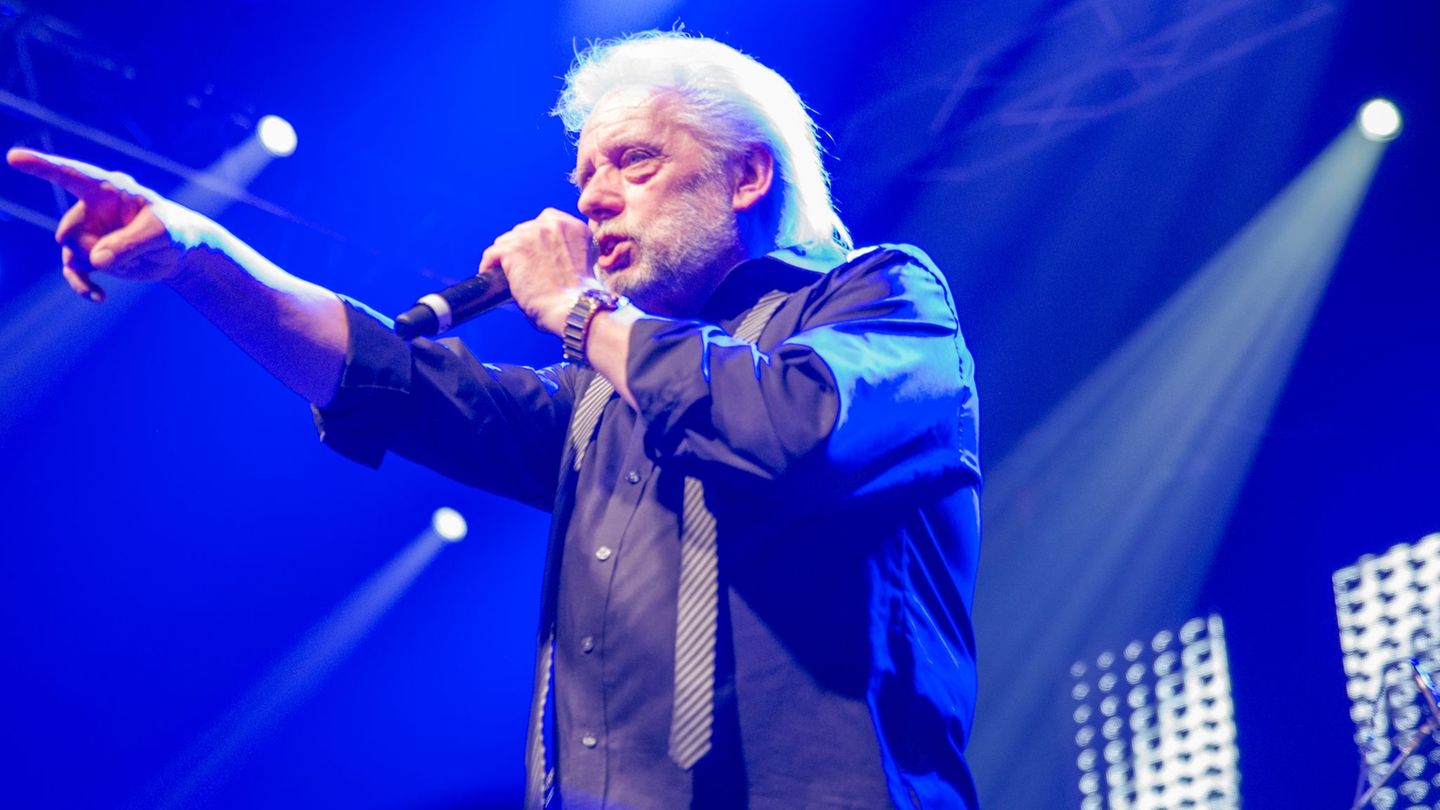 Peter Volkmann steht auf der Bühne und singt in ein Mikro