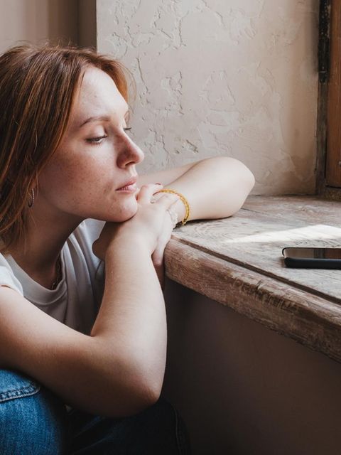 Eine Frau schaut auf ein Handy, das sie zum Dating verwendet