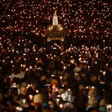 Fatima, Portugal. Am späten Abend wird während der Lichterprozession am Heiligtum von Fátima in Zentralportugal ein Festwagen mit einer Statue der Muttergottes von Fátima getragen. Tausende Pilger strömten zum Heiligtum, um den Jahrestag des Wunders von Fátima zu feiern. Bei diesem Wunder hatten drei Hirtenkinder im Mai 1917 angegeben, die Jungfrau Maria gesehen zu haben.