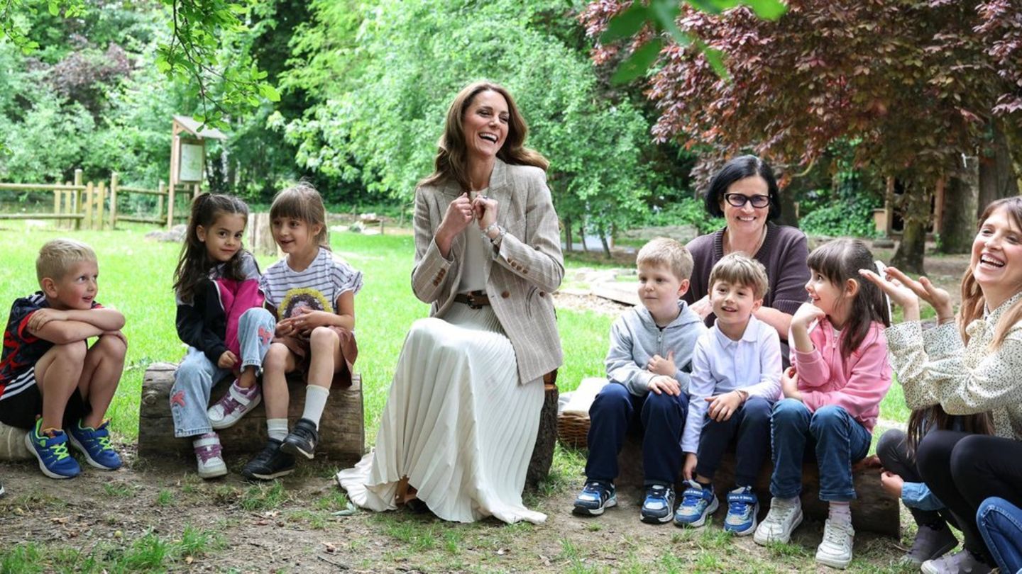 Prinzessin Kate mit Schulkindern in einem Garten.