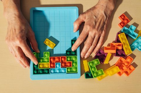 Hände schieben Puzzleteile hin und her