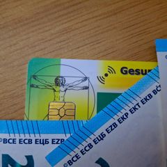 Krankenversicherungskarten und Euro-Scheine liegen auf einem Tisch (Symbolbild)
