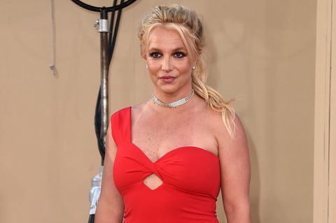 Britney Spears geht in einem roten Kleid über den roten Teppich