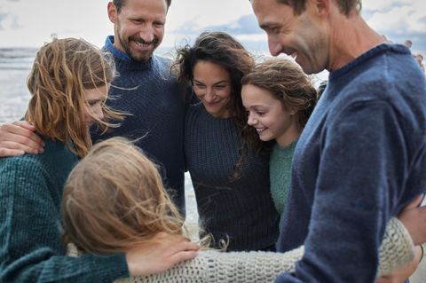 Symbolbild Patchwork-Familie: Familie umarmt sich im Kreis