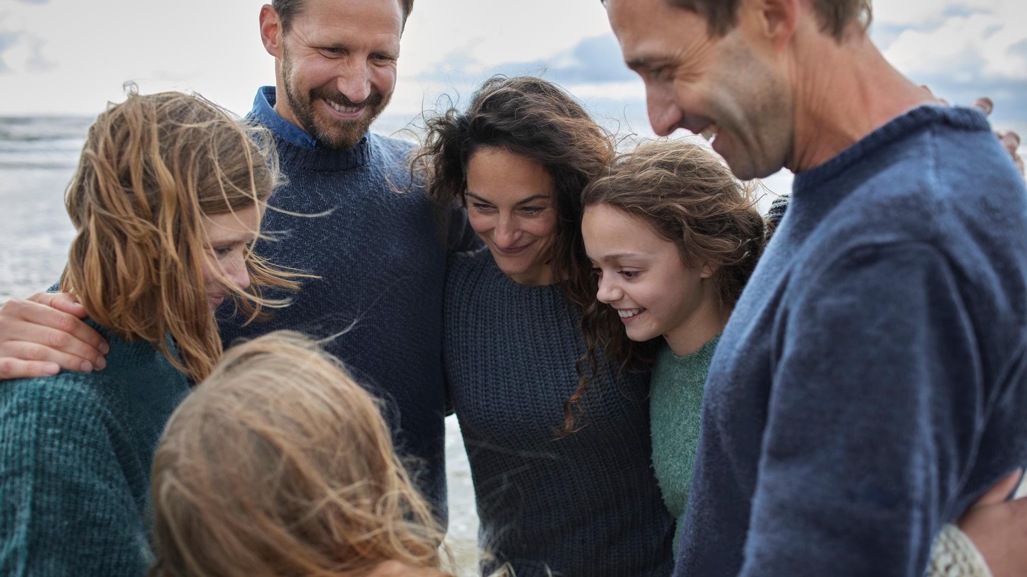 Symbolbild Patchwork-Familie: Familie umarmt sich im Kreis