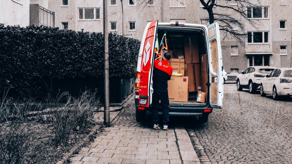 Ein Paketlieferant an seinem vollgepackten Auto