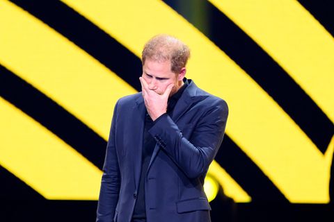 Prinz Harry hält sich eine Hand vor den Mund