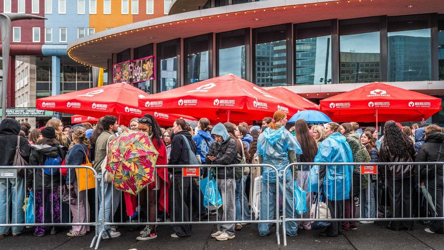 Harry-Styles-Fans stehen in Regenjacken in einer Schlange