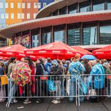 Harry-Styles-Fans stehen in Regenjacken in einer Schlange