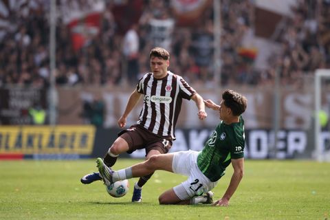 Abstiegskampf pur: Der Wolfsburger Joakim Maehle packt die Grätsche gegen St. Paulis Arkadiusz Pyrka aus. Foto: Christian Charis