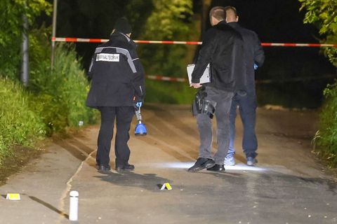 Einsatzkräfte stehen auf einer Straße an einem Tatort und sichern Spuren. Foto: Matthi Rosenkranz/dpa