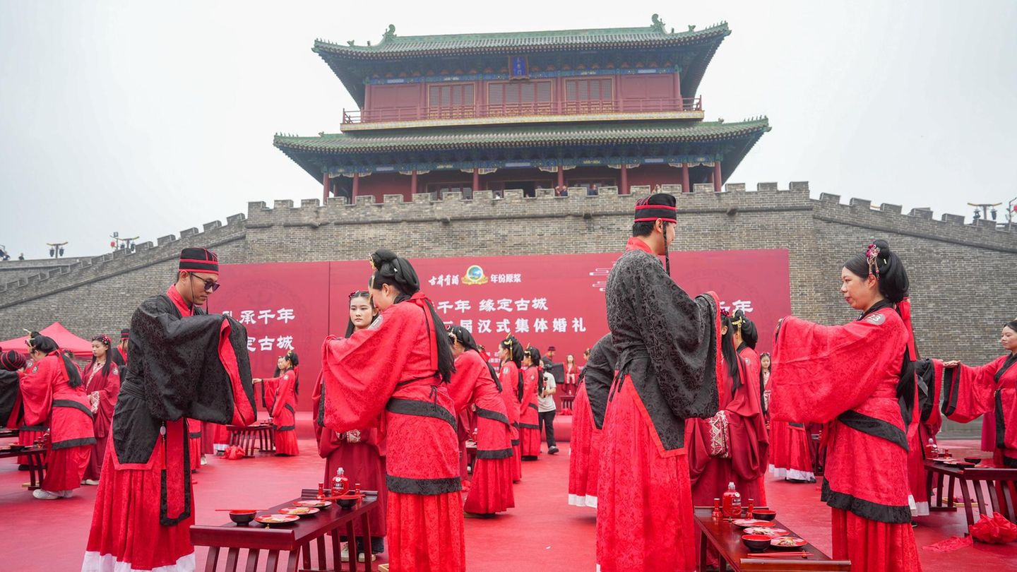 Gruppenhochzeit in traditioneller roter Tracht in China