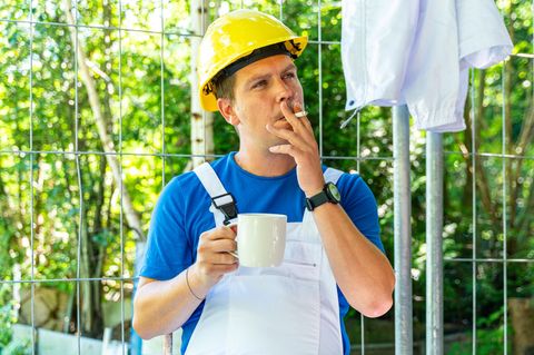 Arbeitszeitgesetz: Mann mit Bauhelm, Tasse und Zigarette
