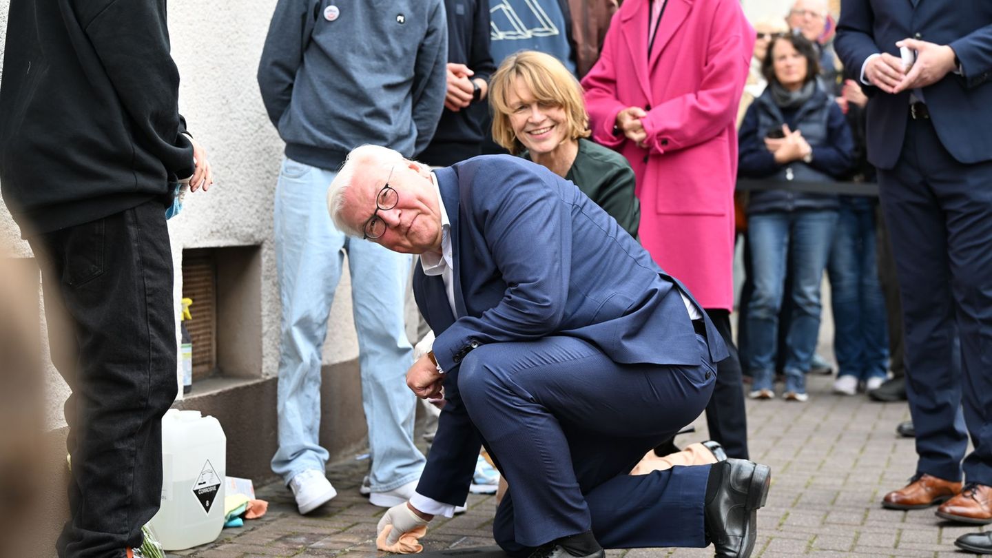 Der Bundespräsident packt persönlich mit an: Er reinigt Stolperstein in Dorsten. Foto: Federico Gambarini/dpa