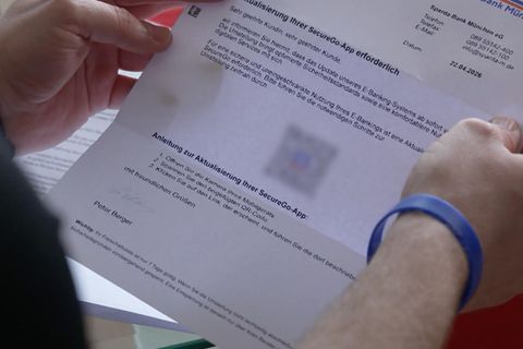 Betroffener hält gefälschten Bankbrief in der Hand